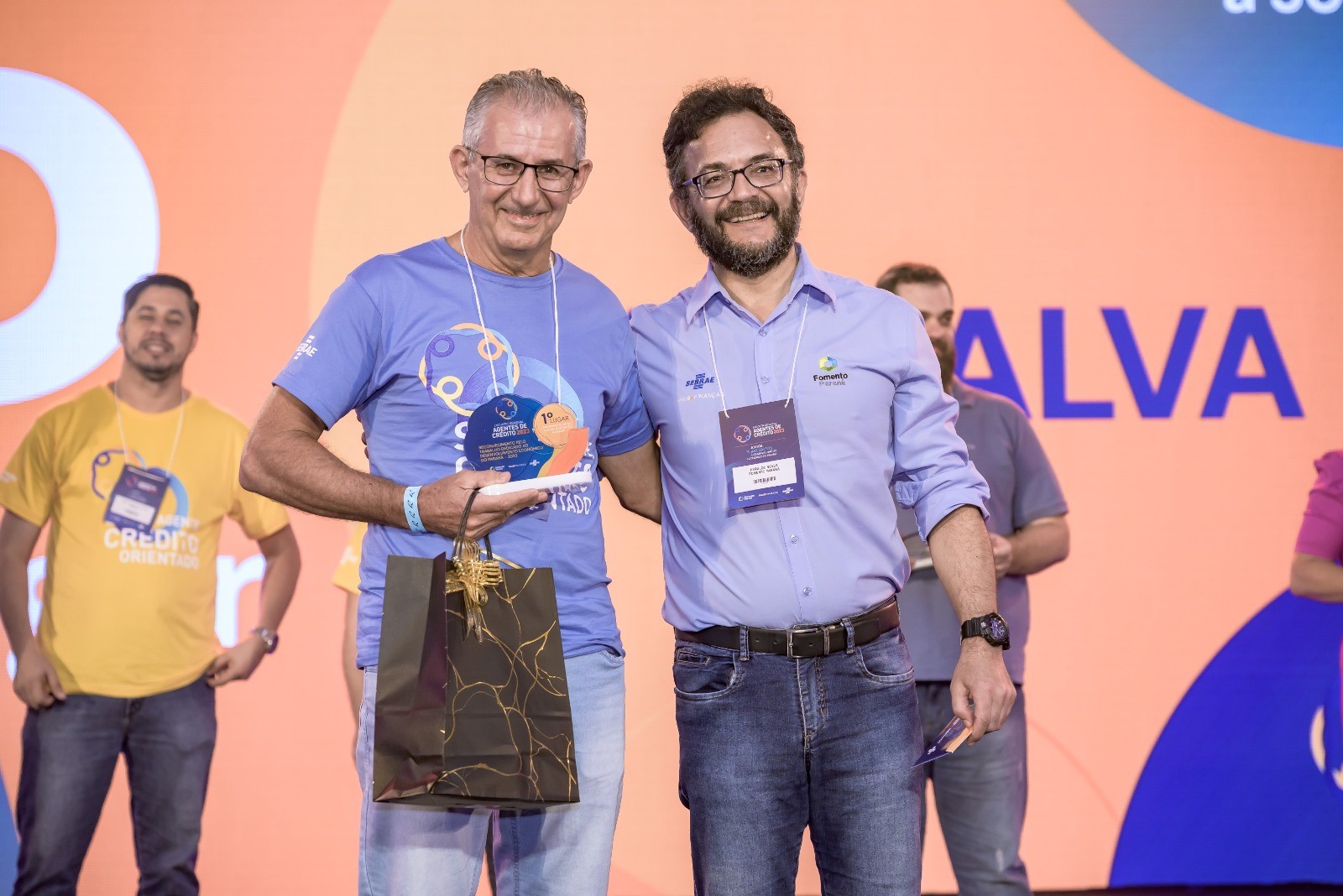 Roberto Carraro, agente de crédito, recebendo premiação do diretor-presidente da Fomento Paraná, Heraldo Neves